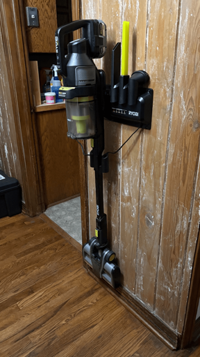 A Ryobi cordless vacuum, mounted to the wall. 